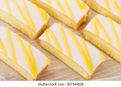 Lemon Drizzle Cake - Slices Of Lemon Cake Topped With Icing.