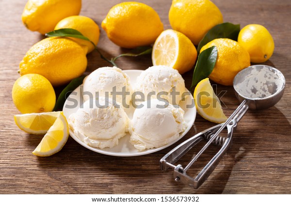 lemon ice cream scoops with fresh fruits on a\
wooden table