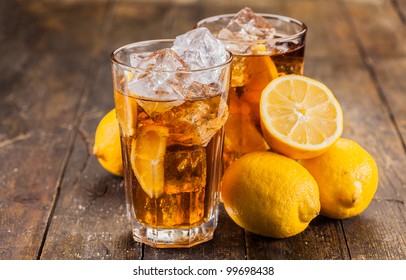 lemon ice tea on brown wooden table with lemons around