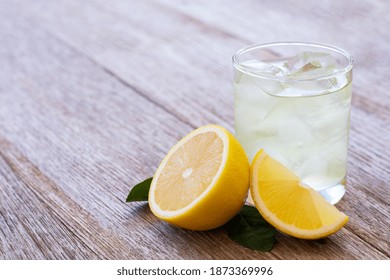 Lemon Juice Or Lemonade With Yellow Limon Slice On Wooden Table Background. Copy Space.