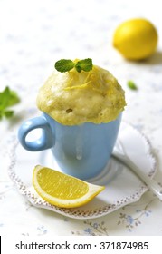 Lemon Mug Cake With Sugar Glaze On A White Table.