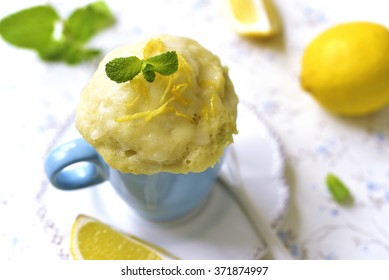 Lemon Mug Cake With Sugar Glaze On A White Table.