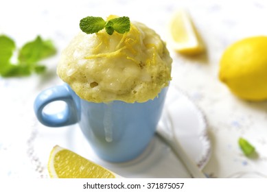 Lemon Mug Cake With Sugar Glaze On A White Table.