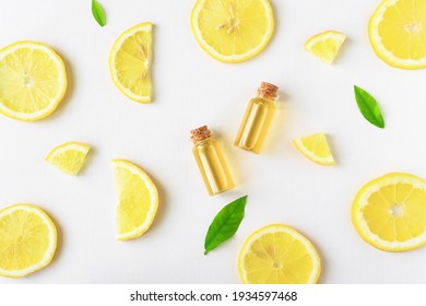Lemon oil in a glass bottle. Aromatherapy. Lemon slices on a white wooden background.