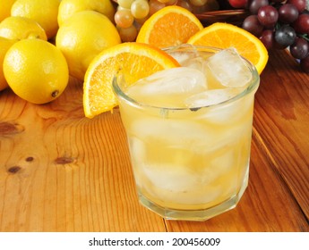 A Lemon And Orange Spritzer On A Wooden Picnic Table