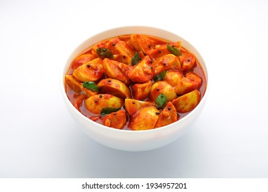 Lemon pickle,hot and sour  red lime pickle arranged  in a white bowl  with   white textured  background.