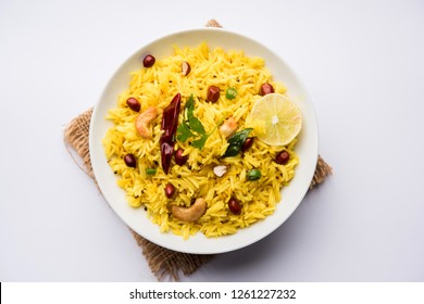 Lemon Rice or fodnicha bhat is South Indian turmeric rice or maharashtrian recipe using leftover rice garnished with nuts curry leaves and lemon juice, selective focus - Powered by Shutterstock