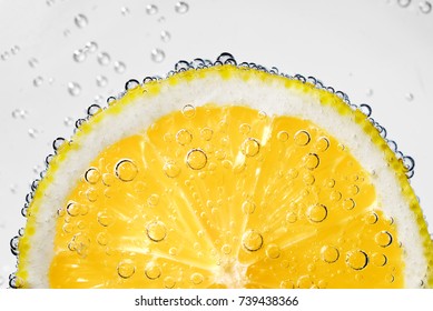 Lemon Slice In Carbonated Soda Fizz Water With Bubbles On White Background