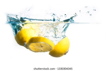 lemon slices fall into the water with splash, isolated on a white background, copy space - Shutterstock ID 1330304345