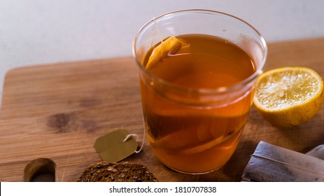 lemon tea infusing in glass cup with biscuits and tea bags - Shutterstock ID 1810707838