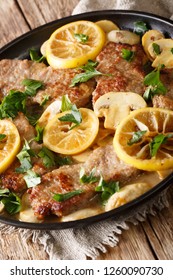 Lemon Veal Scaloppini With Mushrooms In A Sauce Close-up In A Pan On The Table. Vertical
