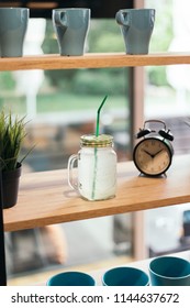 Lemonade Analog Clock And Fake Gras On Wooden Table