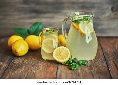 Lemonade drink of soda water, lemon and mint leaves in jug on rustic table background. - Powered by Shutterstock