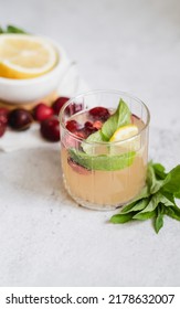 Lemonade In Glass On Light Gray Concrete Background. Fresh Summer Pink Drink With Lemon, Cherry And Mint. Copy Space