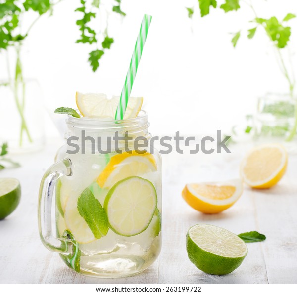 Lemonade With Ice Lemon And Lime Slices In A Jar With Straw In A White