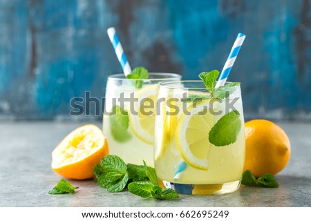 Lemonade or mojito cocktail with lemon and mint, cold refreshing drink or beverage with ice
