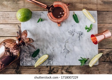 Lemonade or Mojito cocktail making. Mint, lime, ice ingredients and bar utensils on a marble board. Top view. Flat lay