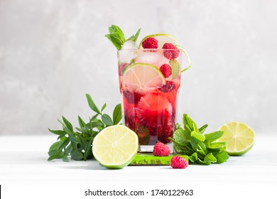 Lemonade Or Non-alcohol Cocktail With Raspberry, Lime And Mint In Glass On Grey Background. Summer Berry Drink.