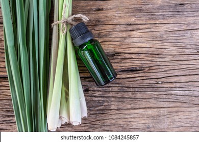 Lemongrass Essential Oil With Fresh Organic Lemongrass On Wooden Background. Spa Concept.