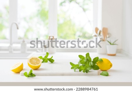 Lemons and mint on marble board over kitchen window background