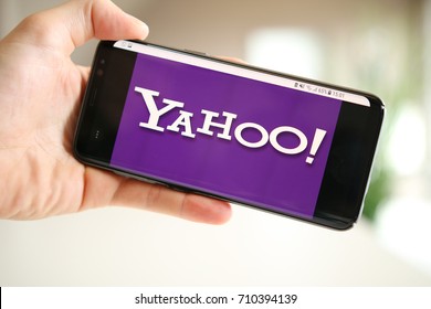 LENDELEDE,BELGIUM-AUGUST 26TH 2017:hand holding a Samsung Galaxy S8 mobile phone which displays the purple logo of the famous search engine Yahoo.Illustrative editorial image on interior background.