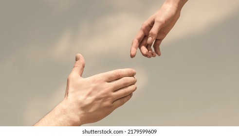 Lending a helping hand. Solidarity, compassion, and charity, rescue. Hands of man and woman reaching to each other, support. - Shutterstock ID 2179599609