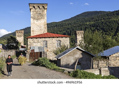 LENGERI, GEORGIA - SEPTEMBER 18, 2016: A Man Carries The Weed On A Wheel Barrow And A Woman  Walks In The Front, In The Village Of Lengeri, In  Caucasus Mountains.