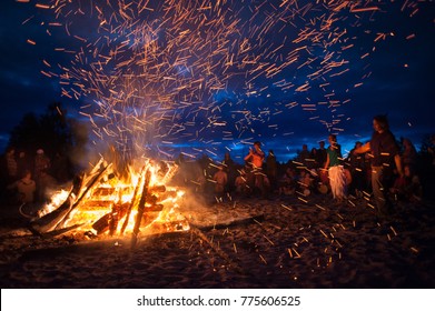 Leningrad Oblast, Russia - July 14, 2015: Big  Tourist Bonfire On The Beach  During The Festival. Young People Dance And Sing Around The Campfire. Deep Night.