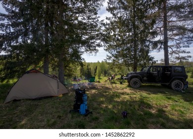 Leningrad Region, Russia, May 29, 2019: Jeep Wrangler Camping In The Forest By The Fire. Wrangler Is A Compact Four Wheel Drive Off Road And Sport Utility Vehicle