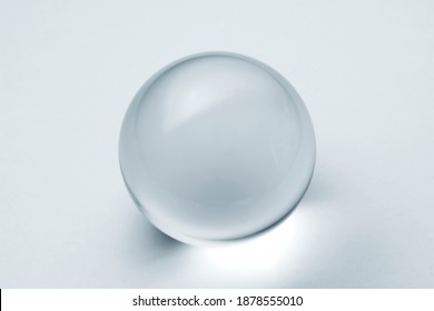 A lens ball in light blue. Glass ball with reflection in silver blue tone.