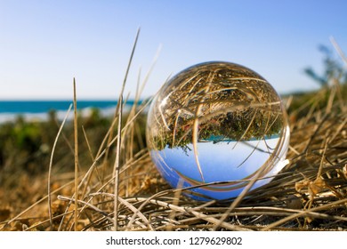 A lens ball placed at the beach for a different perspective.