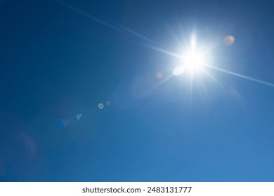 Lens flare effect over deep blue sky with glowing sun - Powered by Shutterstock