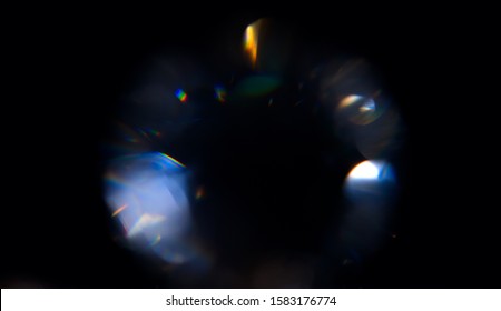 Lens Flare, Round diamond abstract Bokeh Lights. Leaking Reflection of a Glass, Crystal, Defocused Shining Colorful rainbow Light Leaks, Rays on Black Background