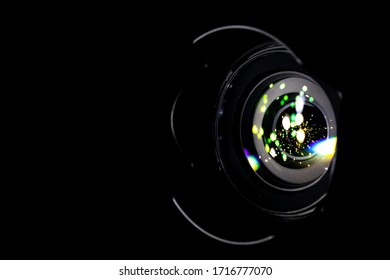 Lense Flare Lights On Shutter. Reflection On Photo, Video Camera On Black Background. Sunlight Abstract Bokeh In Digital Macro Studio Shot.