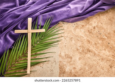 Lent season, Holy week and Good friday concept. Palm leave and cross on stone background - Shutterstock ID 2265257891