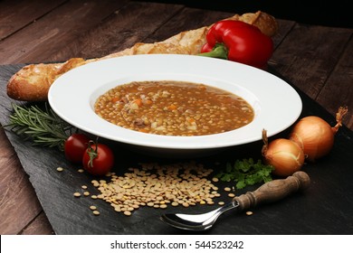 Lentil soup with pita bread in a bowl on a wooden background