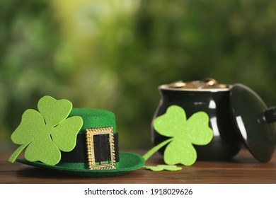 Leprechaun Hat, Clover Leaves And Pot Of Gold On Wooden Table Against Blurred Background, Space For Text. St Patrick's Day Celebration