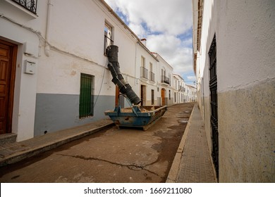 Lerena / Spain - March 05 2020: Rubbish Chute For Building Waste Hangs From A Building Above A Skip On The Street In Llerena Spain