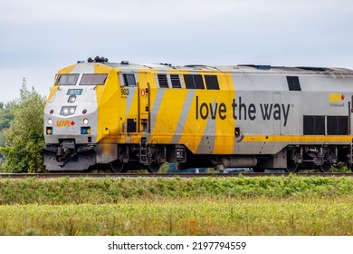 Les Cedres, Canada - September 04, 2022: A Via Rail Passenger Train Travelling Eastbound Through A Green Field