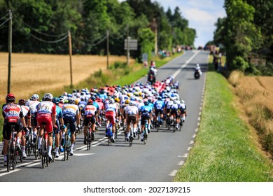Les Vignes du Chateau, France - July 1,2021: Rear image of the peloton riding on a French countryside road during the Tour de France 2021.