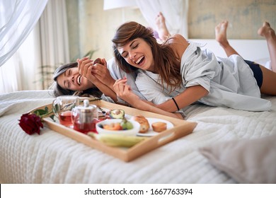 Lesbian, Couple, Breakfast In Bed, Romance Concept. Lesbians  Laughing, Having Breakfast Lying On Bed.