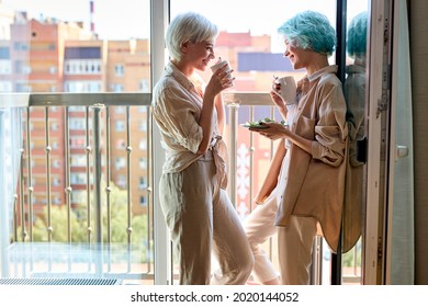 lesbian, couple, breakfast, romance concept. beautiful caucasian lesbian women have breakfast on balcony having talk, enjoying morning together. side view portrait, copy space. people lifestyle - Powered by Shutterstock