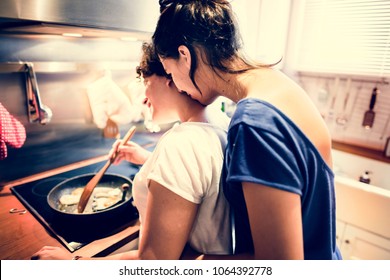 Lesbian couple cooking in the kitchen together - Powered by Shutterstock