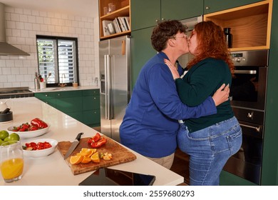 Lesbian couple embracing and kissing in kitchen - Powered by Shutterstock