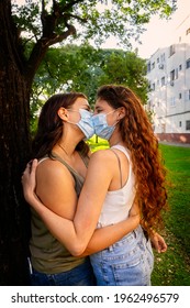 Lesbian Couple Kissing With Mask In The Park