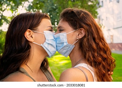 Lesbian Couple Kissing With Mask In The Park