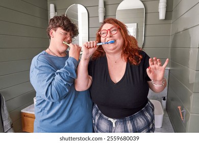 Lesbian couple in pajamas brushing teeth in bathroom - Powered by Shutterstock