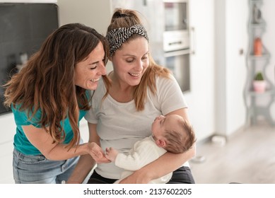 A Lesbian Couple Smiling At Their Baby, Gay Marriage, Gay Parents And Adoption Concept