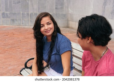 Lesbian Couple Talking On Park Bench. LGBT Concept