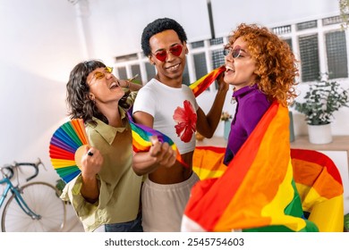 Lesbian couple and transgender friend laughing, singing and dancing, celebrating pride at home - Powered by Shutterstock